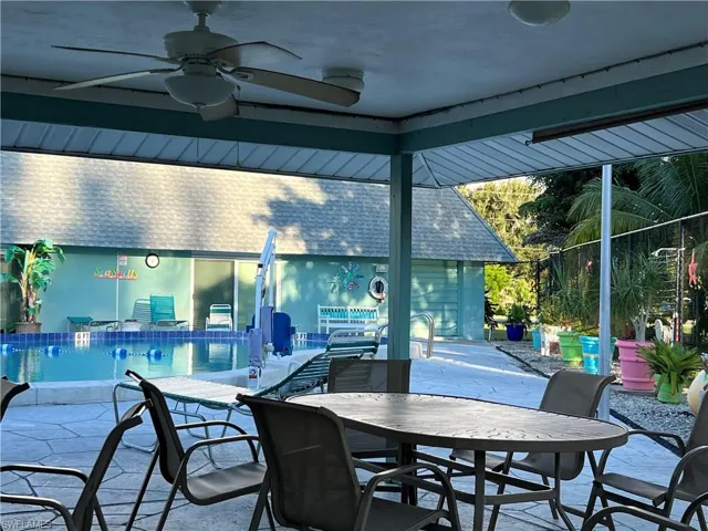 View of patio featuring ceiling fan,dining space, and a community pool