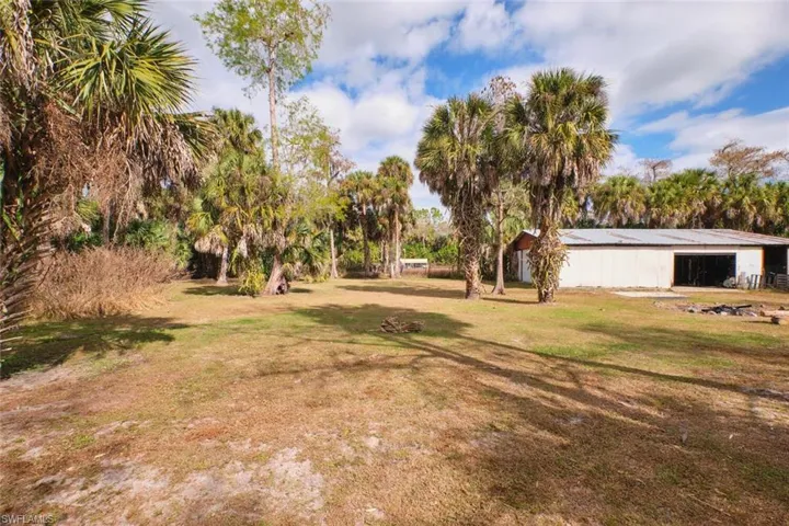 View of grassy yard with an outdoor structure and an outbuilding