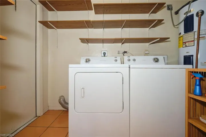 Laundry room featuring water heater,  and independent washer and dryer