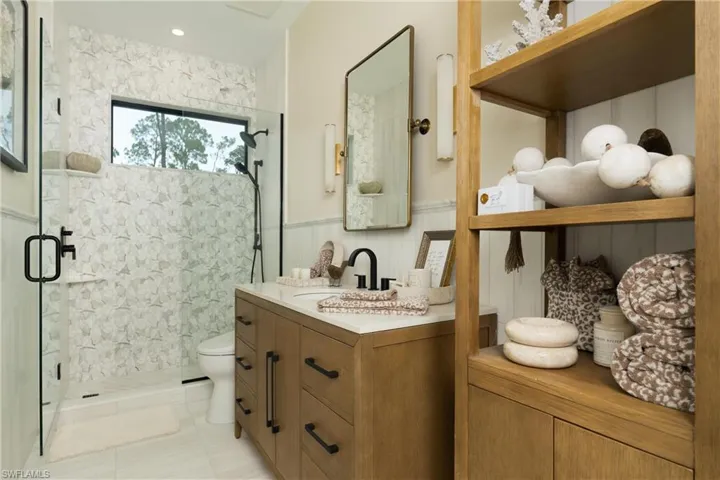 Contemporary bathroom featuring a walk-in shower with patterned tile, a wood-finish vanity with a white countertop, and a wall-mounted mirror
