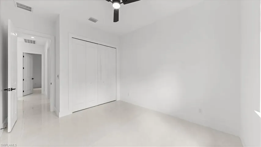 Unfurnished bedroom featuring a closet, ceiling fan, and light tile patterned floors