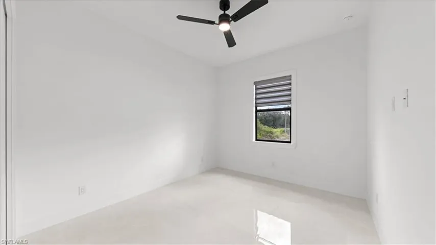 Unfurnished room featuring ceiling fan and baseboards
