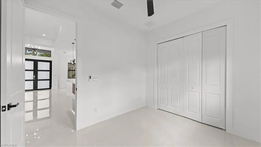 Unfurnished bedroom with a closet, ceiling fan, and french doors