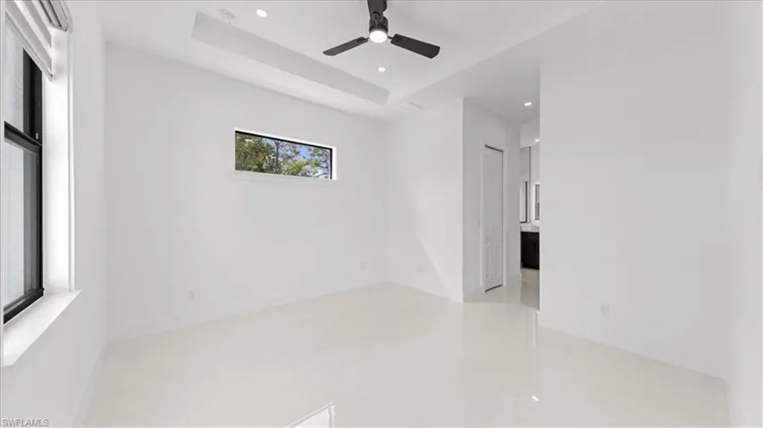 Unfurnished room with recessed lighting, ceiling fan, and a raised ceiling