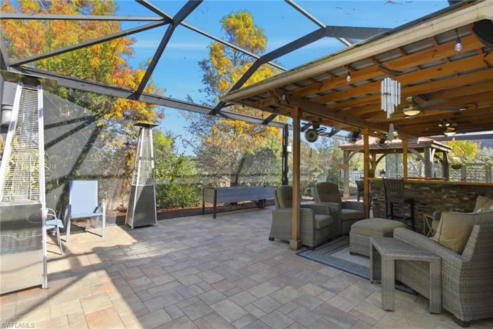 View of patio / terrace featuring a sunroom, glass enclosure, and ceiling fan