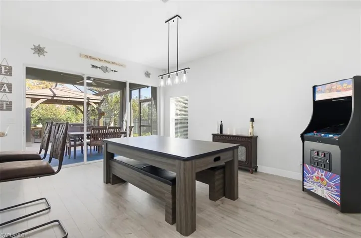 Dining space with light wood-type flooring, a sunroom, and a ceiling fan