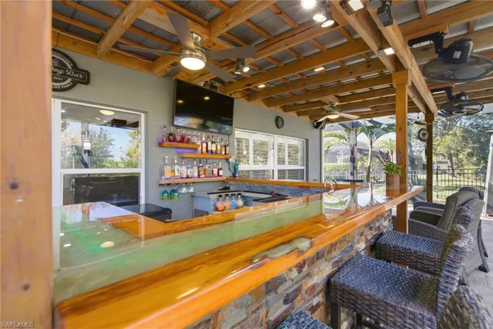 Indoor wet bar with ceiling fan and open shelves