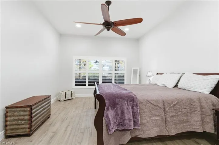 Bedroom with wood finished floors, ceiling fan, and recessed lighting