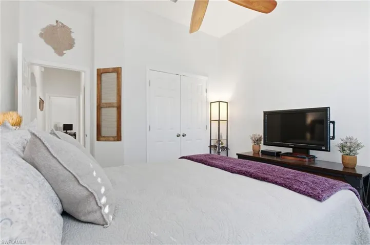 Bedroom with a closet, high vaulted ceiling, and ceiling fan