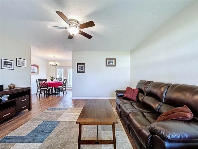 Living room featuring wood-look vinyl plank floors, and a ceiling fan
