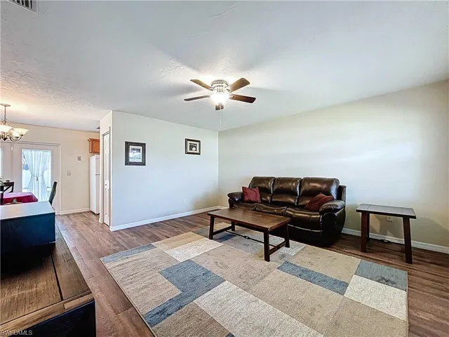 Living room featuring wood-look vinyl plank floors, and ceiling fan