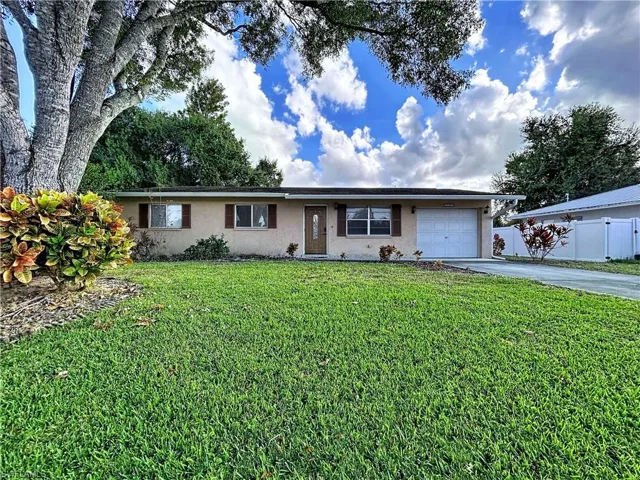 Ranch-style home with driveway, stucco finish