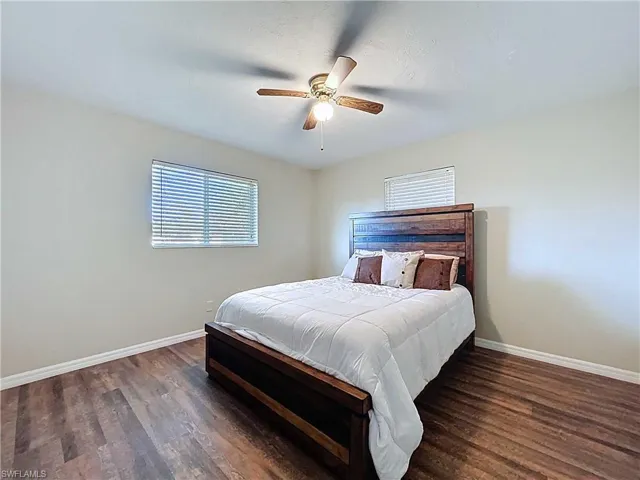 Bedroom with dark wood-style floors and ceiling fan