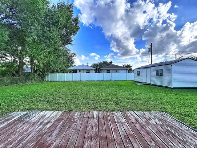 Deck featuring a fenced backyard and a spacious shed.