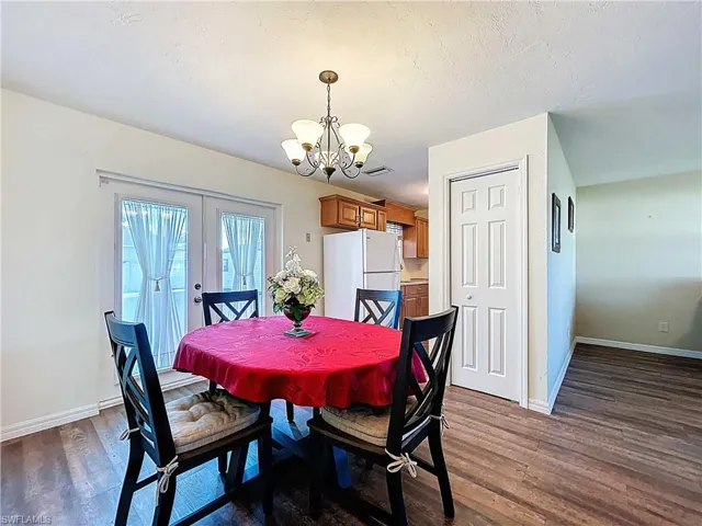 Dining space with wood-look vinyl plank flooring, and a chandelier