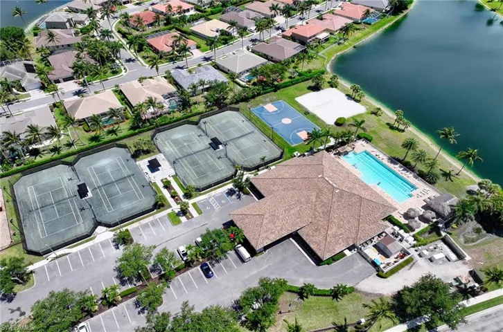 Aerial view of Main Clubhouse and surrounding area with a pool, Tennis Courts, Basket ball court and a nearby body of water