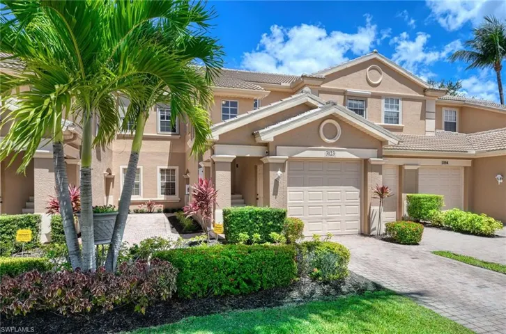 Townhome / multi-family property with stucco siding, decorative driveway, and a tiled roof