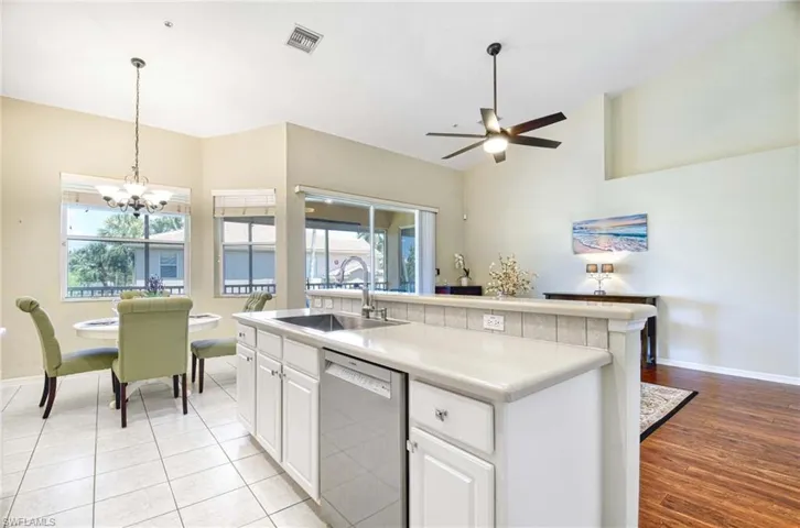 Kitchen with dishwasher, a sink, baseboards, and a chandelier