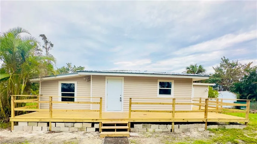 Back of house with a deck and metal roof
