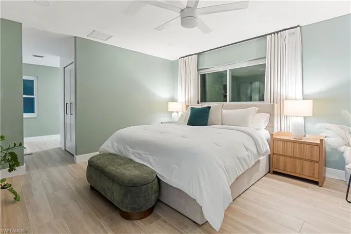 Bedroom featuring light wood-type flooring, ceiling fan, attic access, and a closet