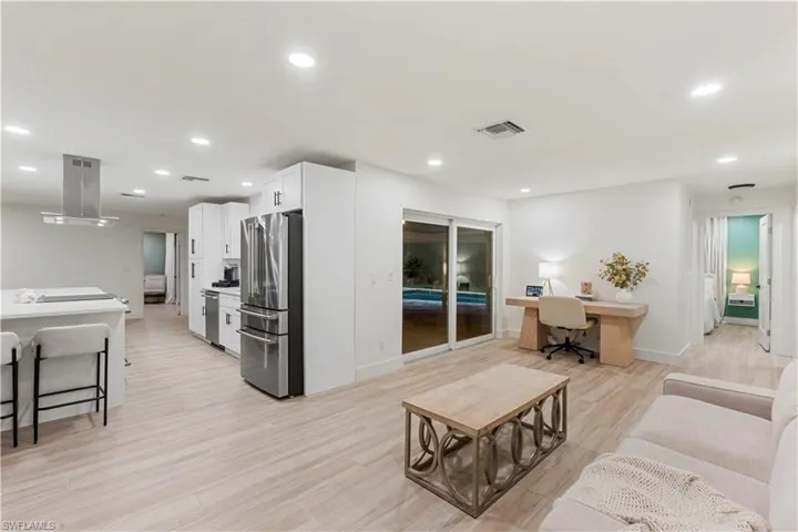 Living area featuring light wood-style floors, recessed lighting, and built in desk