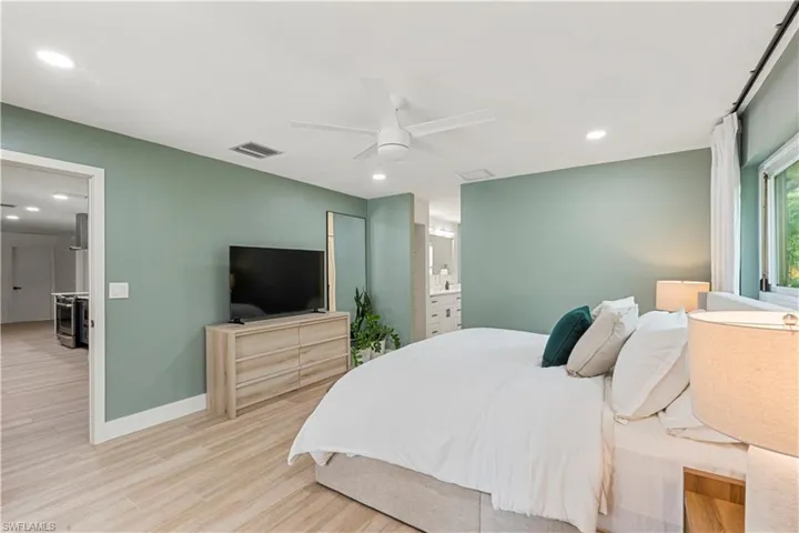 Bedroom with recessed lighting, wood finished floors, ceiling fan, and connected bathroom
