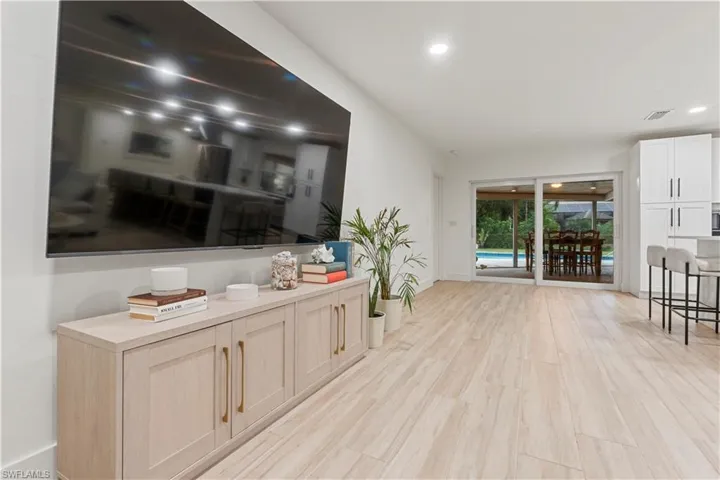 Living room featuring light wood finished floors, recessed lighting, and a sunroom