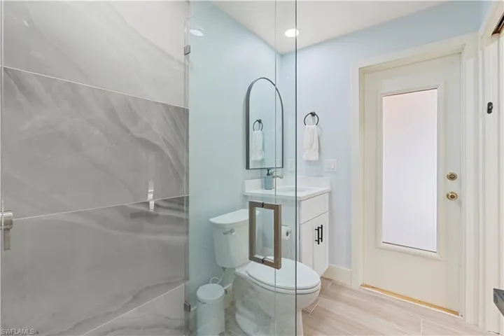 Bathroom with vanity, light wood finished floors, and a shower stall