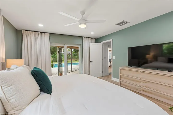 Bedroom with access to exterior, light wood finished floors, ceiling fan, and recessed lighting