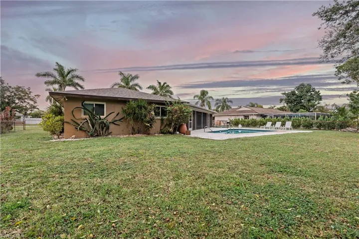 Back of property featuring a sunroom, stucco siding, and a patio area