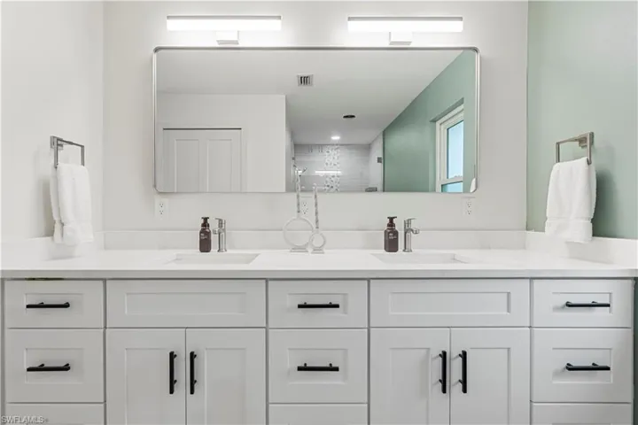Bathroom featuring double vanity and a shower stall
