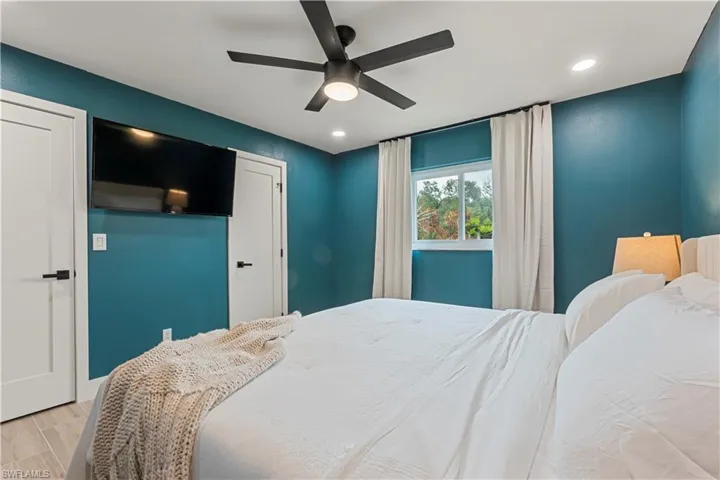 Bedroom with light wood-style floors, a ceiling fan, and recessed lighting