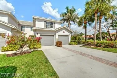 Traditional-style home with driveway, an attached garage, and stucco siding