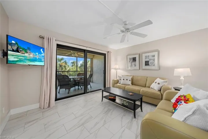 Living area featuring large format tile flooring and direct access to an outdoor screened patio