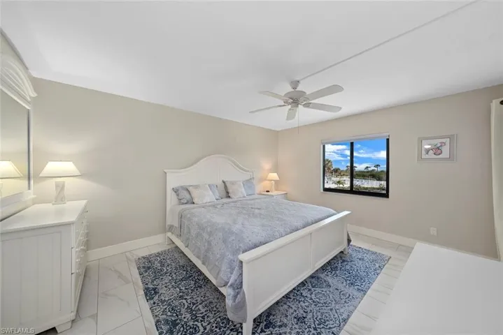 Bedroom featuring a ceiling fan, a window with exterior scenery, and light-toned walls