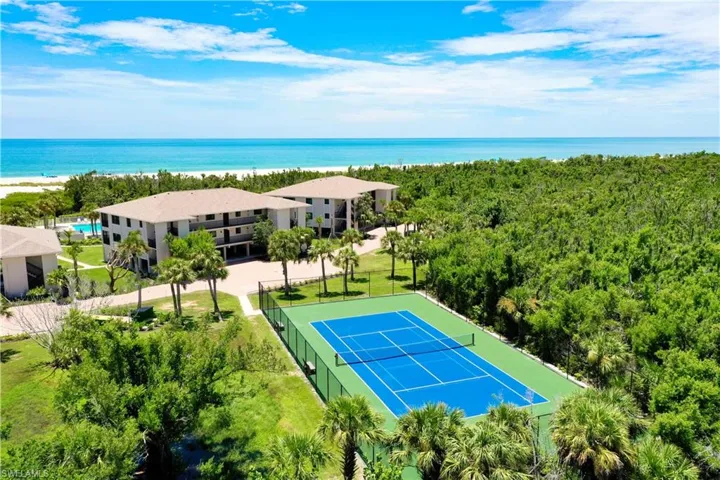 Tennis court with blue playing surface and green surrounds
