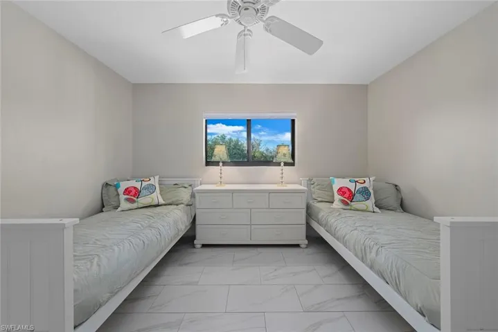 Recessed window with exterior scenery, white ceiling fan with integrated lighting, light gray wall paint, and large format white tile flooring