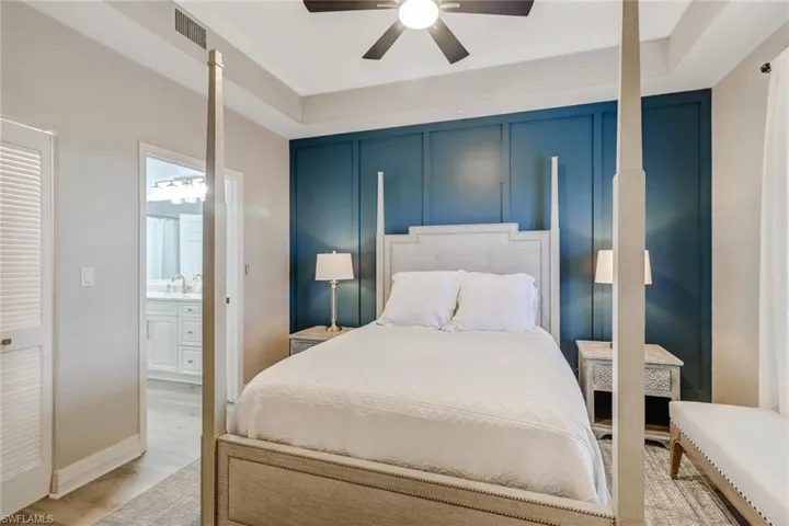 Bedroom with ensuite bath, light wood-style flooring