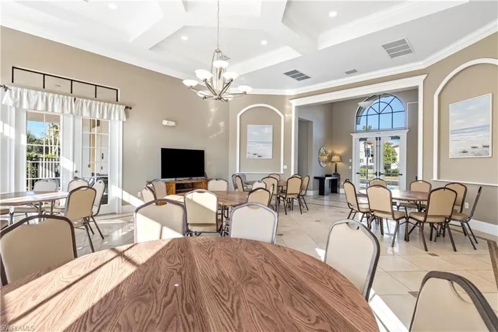Tiled dining room with a wealth of natural light, crown molding, french doors, and coffered ceiling