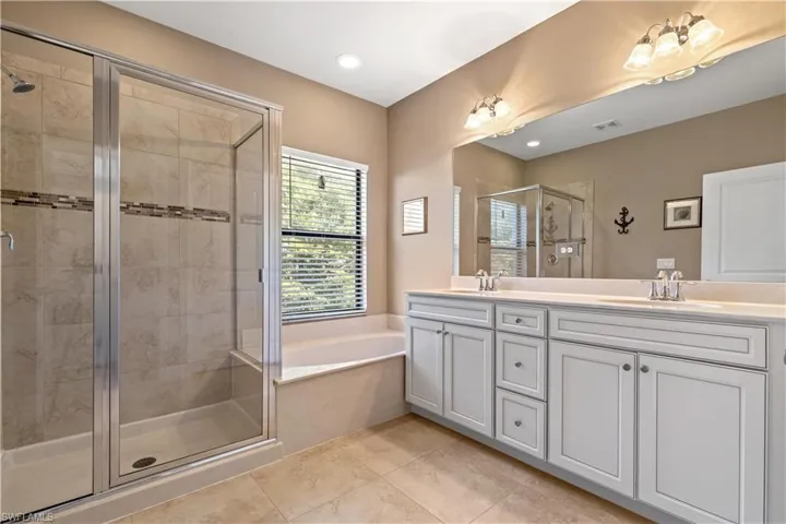 Primary Bathroom with plus walk in shower, vanity, and tile patterned floors