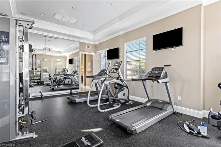 Exercise room featuring a tray ceiling and ornamental molding