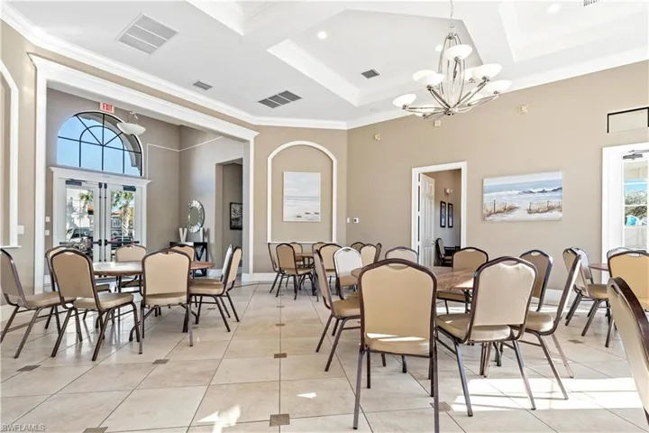 Dining space featuring a notable chandelier, plenty of natural light, light tile patterned flooring, and ornamental molding