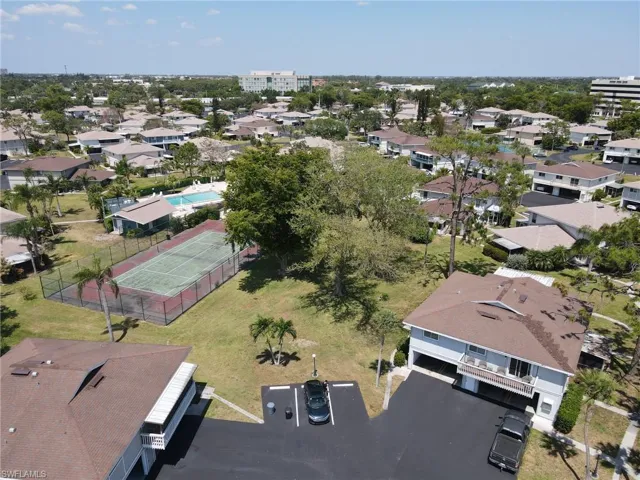 A great view of building, outdoor open space and tennis court.