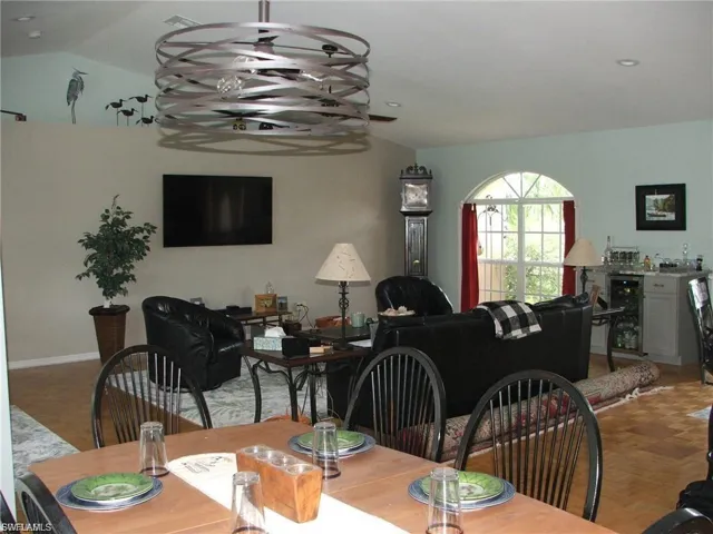 Dining room with beverage cooler, lofted ceiling, and parquet flooring