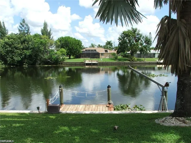 Dock with a water view and a lawn