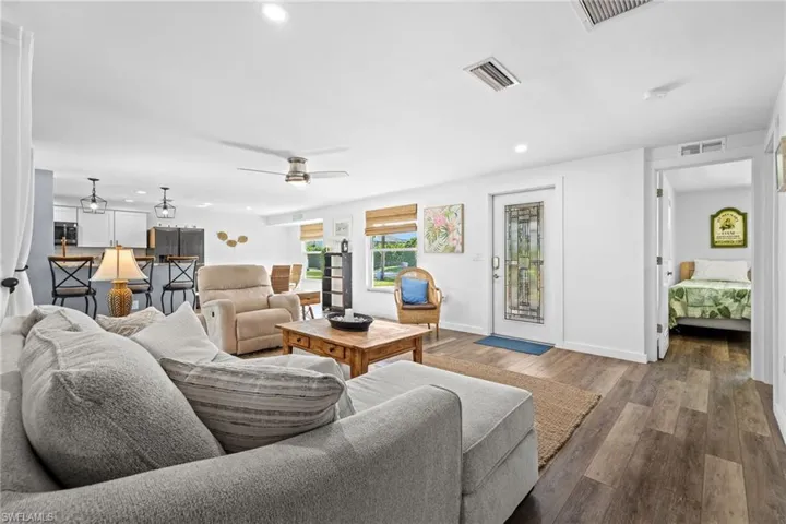 Spacious living area with wood-finish flooring, recessed lighting, and a ceiling fan