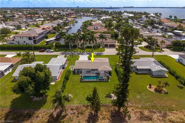 Property featuring a private swimming pool, screened enclosure, and an expansive manicured lawn