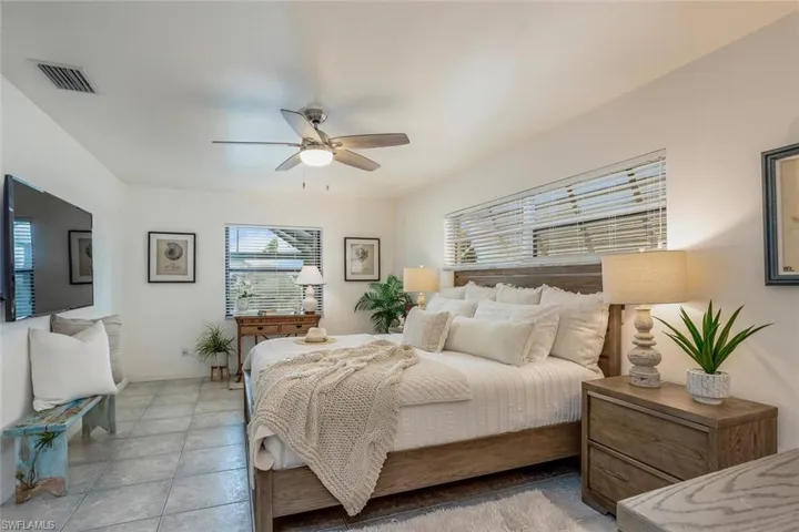 Tiled bedroom featuring ceiling fan