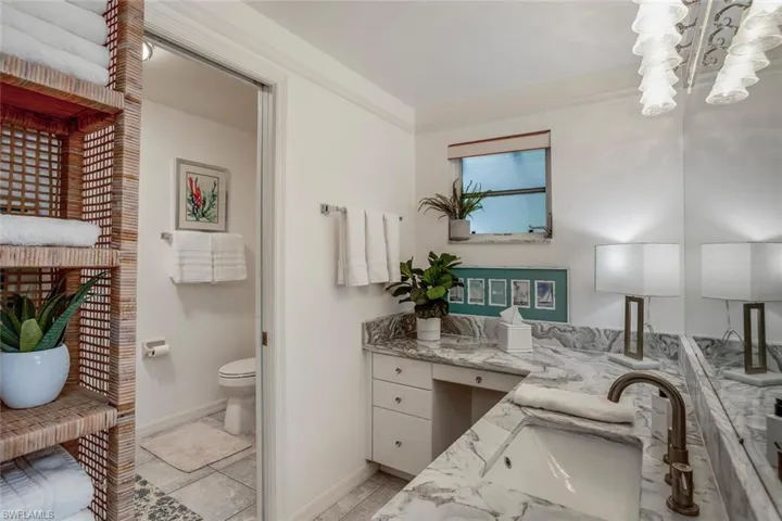 Bathroom featuring crown molding, vanity, and toilet