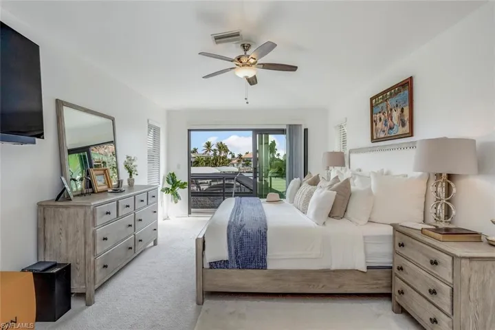 Carpeted bedroom with access to outside and ceiling fan